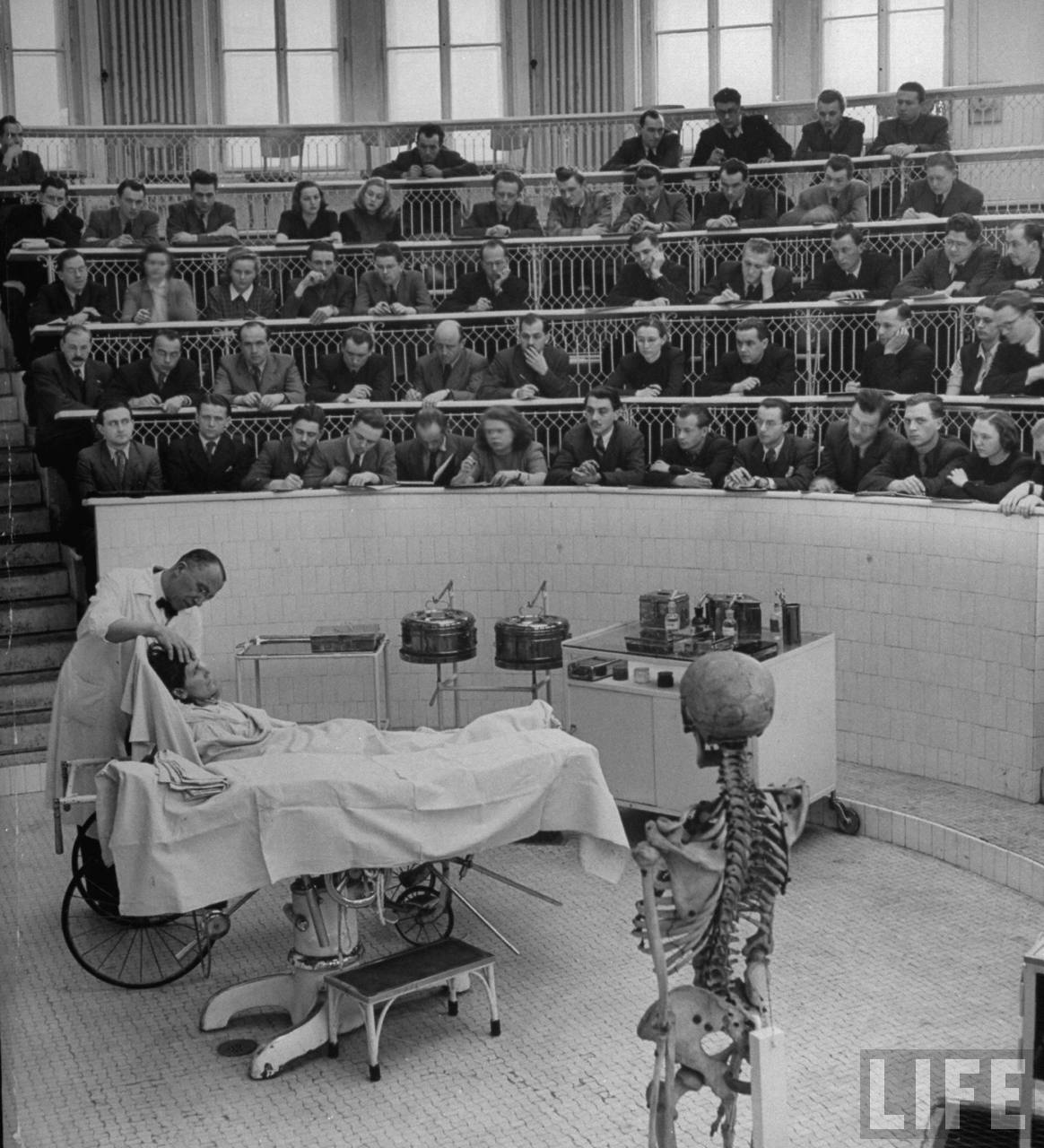 Brain surgeon Arnold Jirasek describing technique of operating on woman with a severely abscessed jaw to medical students from Charles University in amphitheater of his Clinic of Surgery.