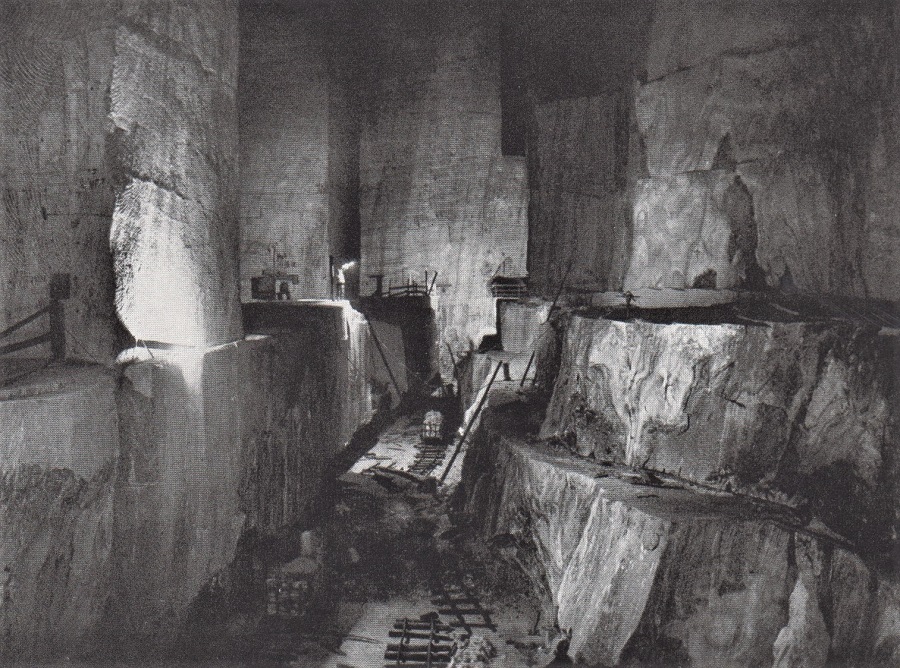 A HUMAN GLOWWORM STANDS IN A CAVERN CARVED FROM SALT. 